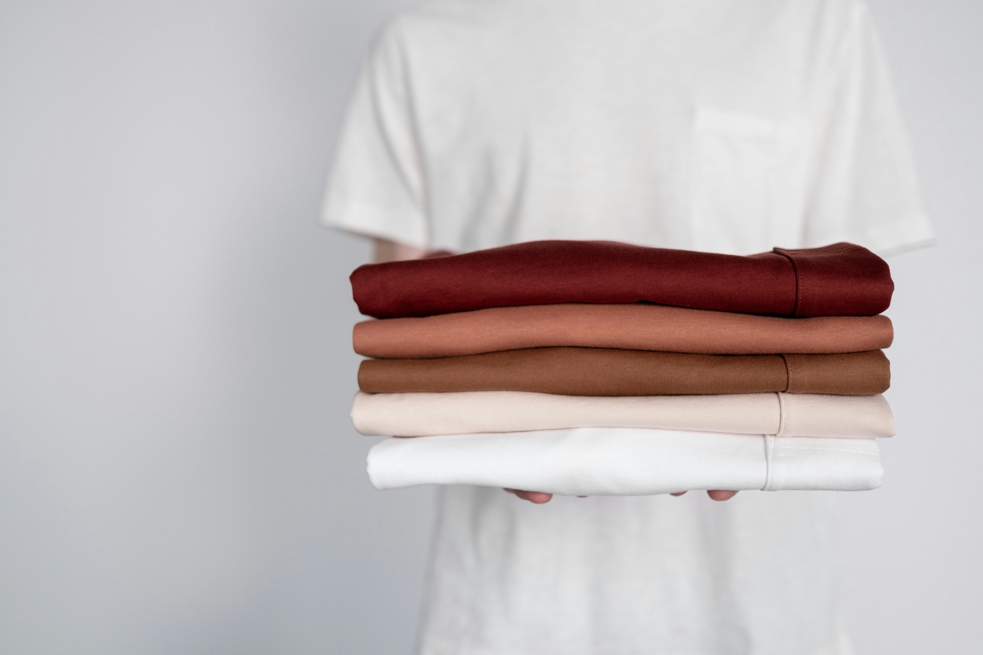 Stack of folded blank t-shirts in different fabrics and weights ready for sampling and printing