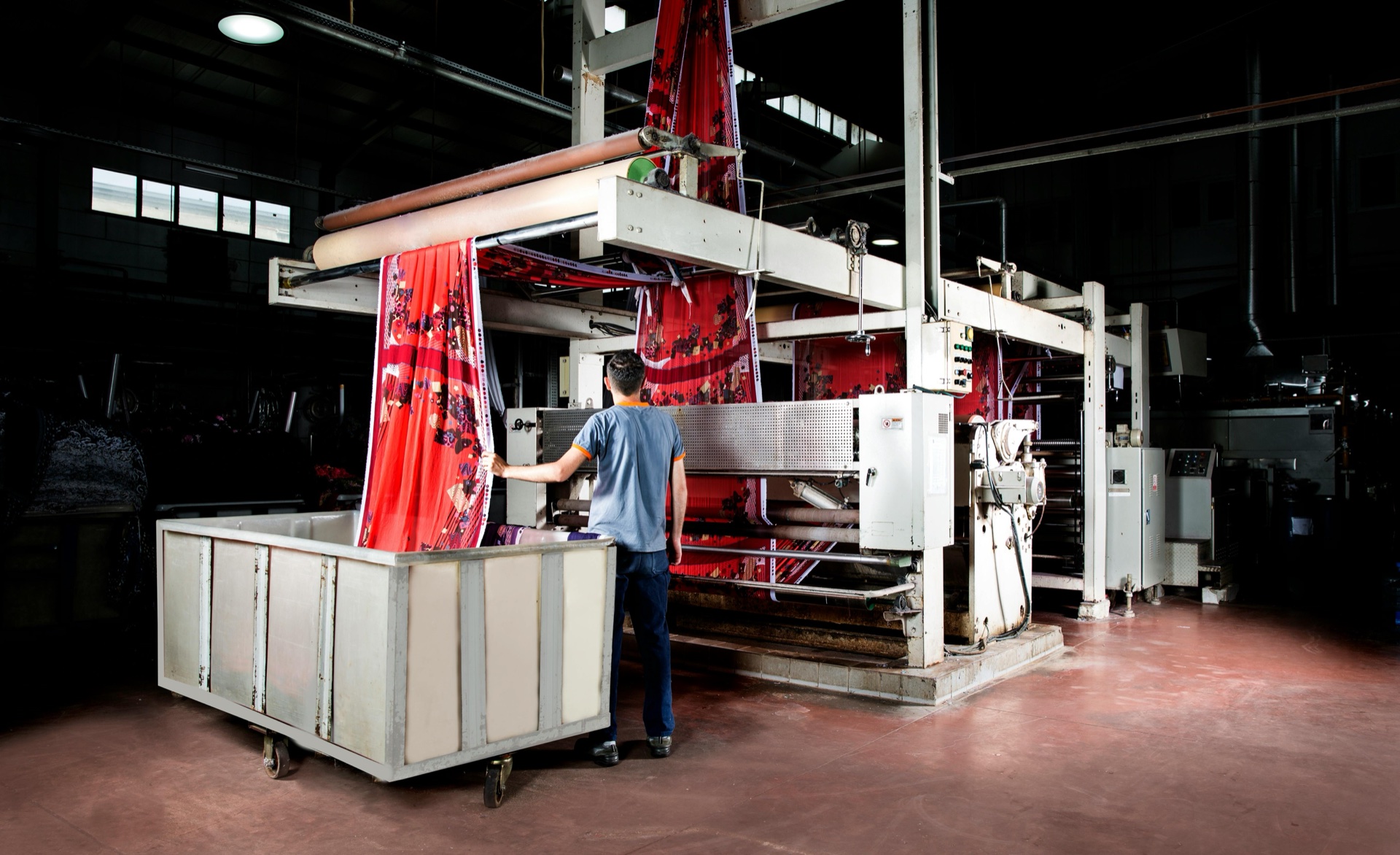 Rolls of printed silk fabric arriving at the finishing stage of scarf production