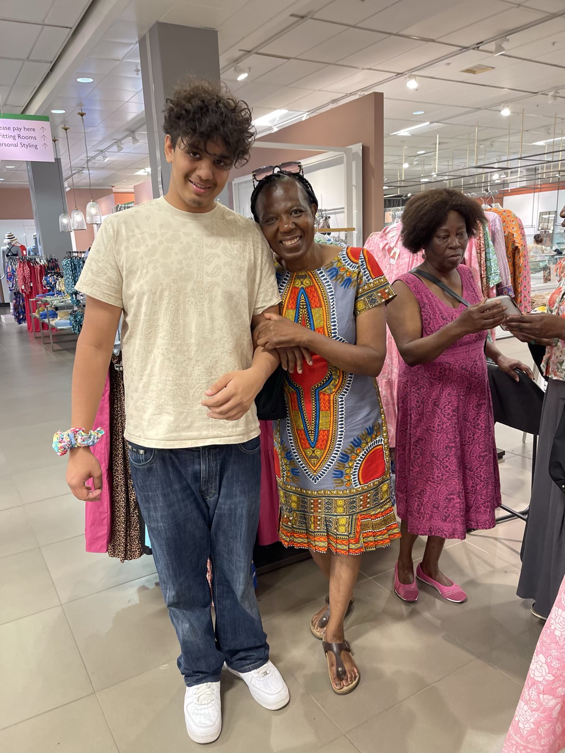 Bhavna Rishi arm in arm with a family helper and a smiling customer on the shop floor at the DesignerFriday popup.