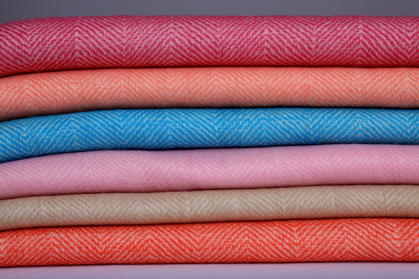 Assorted herringbone wool scarves in the full seasonal range of colourways.